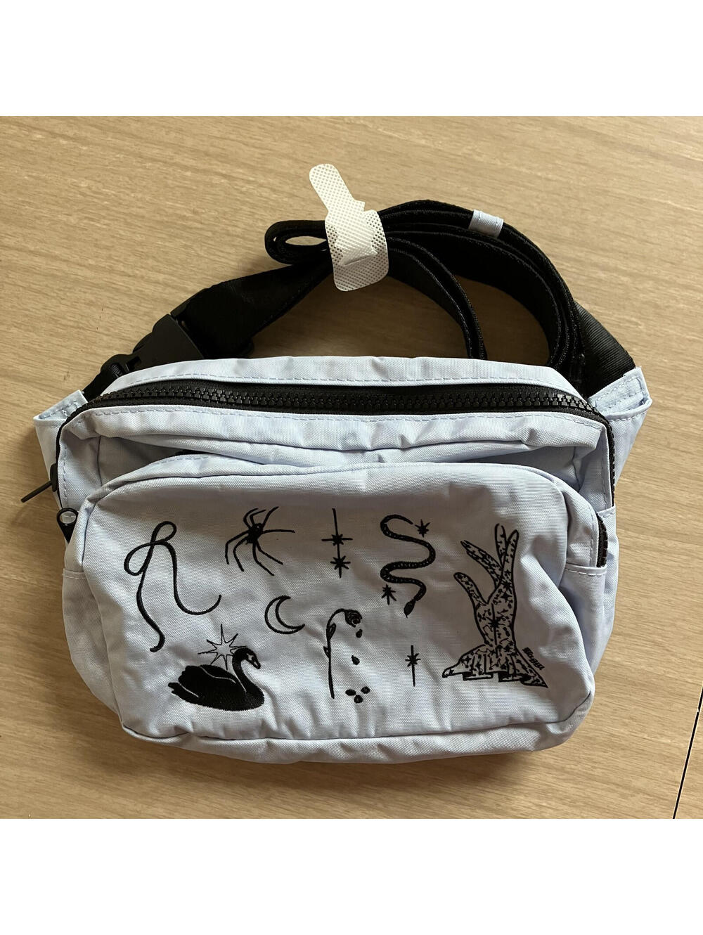 BAGGU light gray crossbody belt bag with black graphic accents